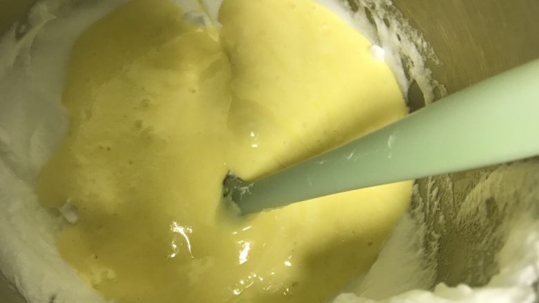 八寸满模酸奶戚风蛋糕,搅拌均匀后直接将蛋黄糊倒入蛋白中翻拌均匀,千万不要画圈搅拌,画圈会使蛋白消泡,导致蛋糕涨不起来
