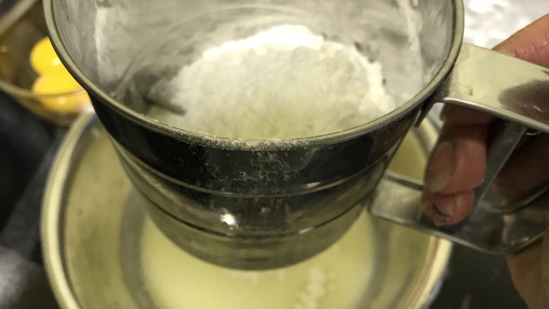 八寸满模酸奶戚风蛋糕,低筋面粉和玉米淀粉混合,高空(20公分左右)筛入搅拌好的酸奶糊中
