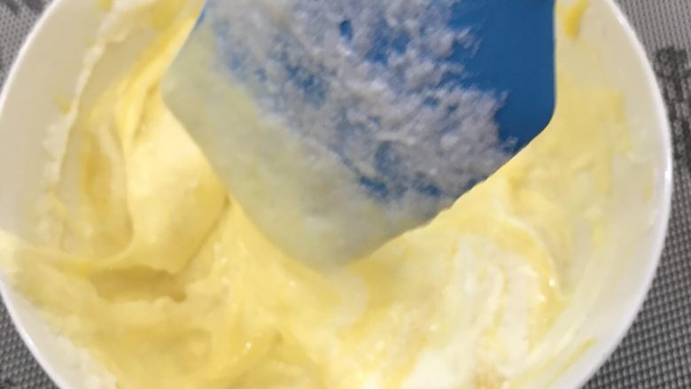 奶牛蛋糕卷,抓紧混合蛋黄糊和蛋白霜部分,先取三分之一蛋白霜至蛋黄糊中,切拌混匀