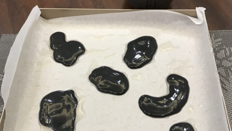 奶牛蛋糕卷,将竹炭糊先挤入烤盘,烤箱烤三分钟定型