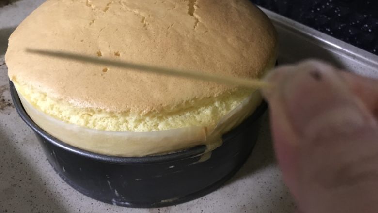八寸满模酸奶戚风蛋糕,检查蛋糕是否烤好最简单的方法就是用牙签插入,看看牙签是否带出蛋糕屑,如没有就表示蛋糕好了,现在蛋糕已经满模,涨出了