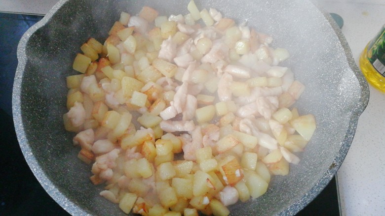 香煎土豆鸡胸肉丁,煎至鸡丁变色八分熟时,再与土豆丁一起炒均匀;