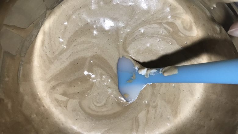 可可榛子萨瓦林蛋糕,先分三分之一的蛋白糊来和刚才的巧克力蛋黄糊混合,用切拌的方式,混合均匀了,再加三分之一的蛋白糊,再搅拌均匀,最后把全部的蛋白糊和蛋黄糊混合均匀就可以。