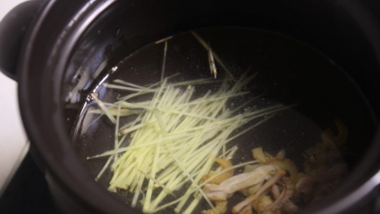 潮汕砂锅粥,用煲粥的砂锅加入三分之一的水,将虾米,干贝,鱿鱼一起加入,再加入姜。