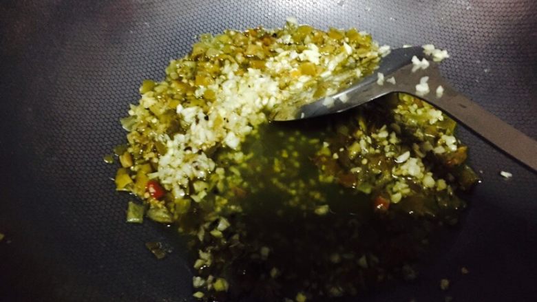 双椒鱼头,锅中放油烧开,放青剁椒、姜末蒜末花椒、豆豉、青辣椒、少许生抽、少许老抽、鸡精、炒香