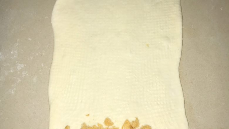 葱香芝士香肠面包,桌面撒少许面粉,光滑面朝下,防卷起时粘桌面。然后将面团擀开,擀长。可以放上<a style='color:red;display:inline-block;' href='/shicai/ 432'>肉松</a>,热狗,或者培根、火腿肠。