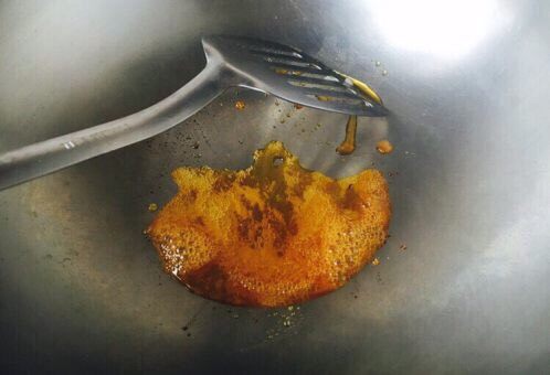 莲藕烧排骨(附无水无油炒糖色技巧),刚开始融化后的状态如图中中间部分,图中左右两边已经产生气泡,当中间部分也产生气泡后用铲子迅速滑动,