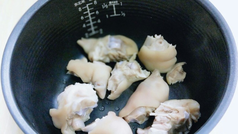 黄豆猪脚汤#电饭煲版#,加入泡好的薏米和黄豆。焯水并洗干净的猪脚加入电饭煲中。