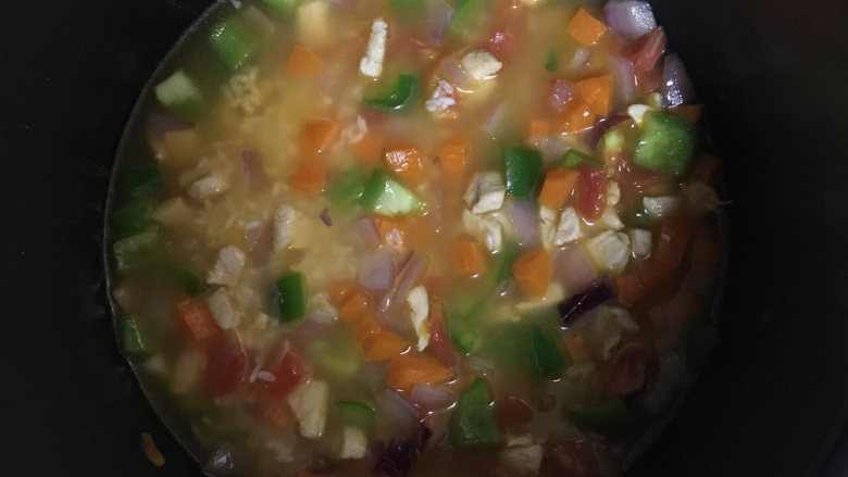 快手菜—茄汁鸡肉焖饭,接着,将全部食材倒入电饭煲中,加入清水,按开启煮饭模式,将饭煮熟