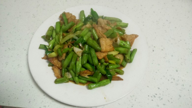豆角炒肉片,盛入盘中。