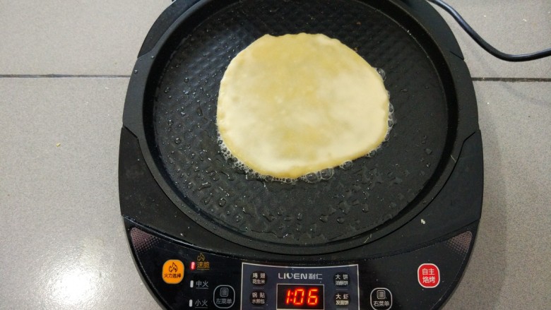 金灿灿—鸡蛋灌饼,预热完毕,倒一些油用硅胶刷刷匀,放入饼胚,电饼铛上层也要抹油,盖上盖子。
