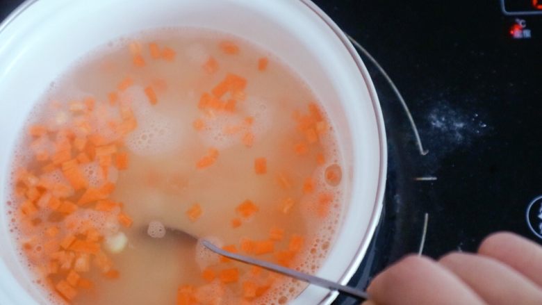 宝宝辅食之玉米胡萝卜粥,倒入后需用勺子经常搅拌以免糊锅,这里我们可以用中小火慢慢熬