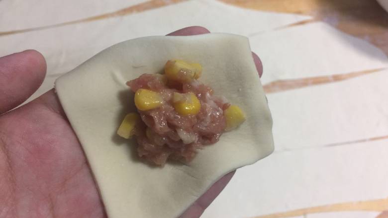 猪肉玉米馄饨,放入馅 梯形的上底与下底捏合