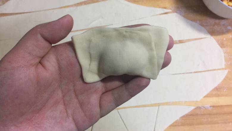 猪肉玉米馄饨,像这样 在再把两个窄端捏合