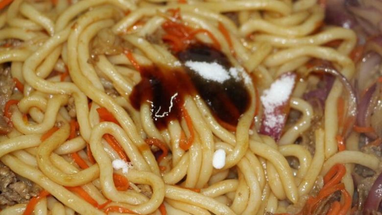 肥牛炒乌冬,倒入蚝油、砂糖,快速翻炒均匀