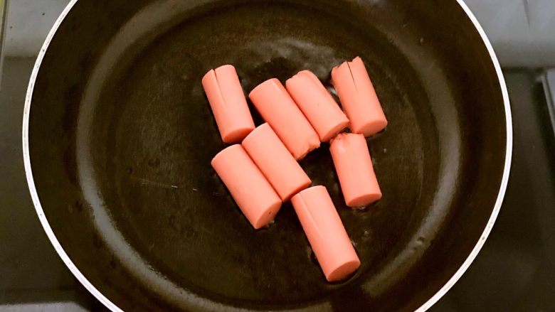 干锅千页豆腐,把火腿肠放入锅里,小火煎制3分钟左右