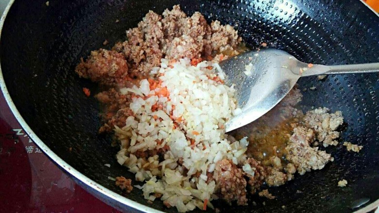 滚筒砂锅酱肉西蓝花馄饨,倒入胡萝卜末和圆葱末,继续翻炒两分钟,入味。