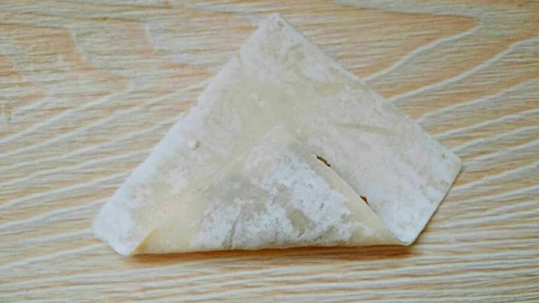滚筒砂锅酱肉西蓝花馄饨,取一角向上折。