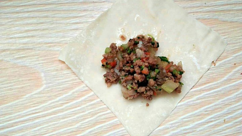 滚筒砂锅酱肉西蓝花馄饨,馄饨皮放在面案上,然后放入适量的馅料。