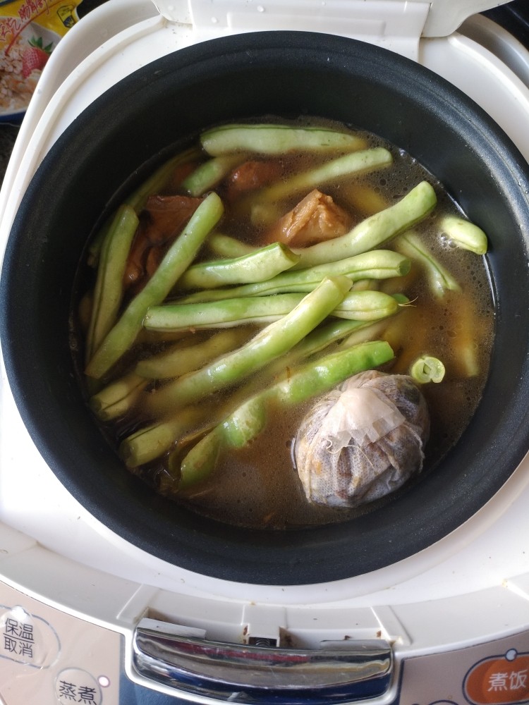 电饭煲-豆角焖面,放入<a style='color:red;display:inline-block;' href='/shicai/ 3639'>豆角</a>和<a style='color:red;display:inline-block;' href='/shicai/ 189992'>调料包</a>加没过<a style='color:red;display:inline-block;' href='/shicai/ 3639'>豆角</a>的开水。