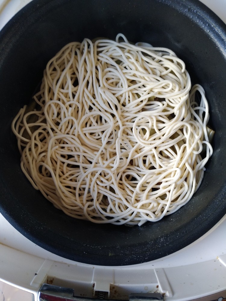 电饭煲-豆角焖面,把面上的干粉抖干净，薄薄的在豆角上铺上一层面。