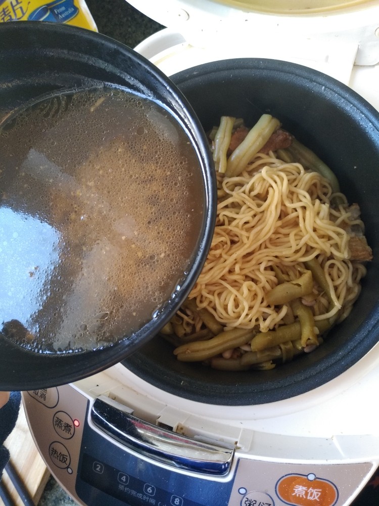 电饭煲-豆角焖面,等到面条吸收完锅里的汤汁把面条和豆角均匀的拌在一起。如果感觉面条还是有点硬就可以到一些刚才留下的汤。在盖盖焖5分钟。