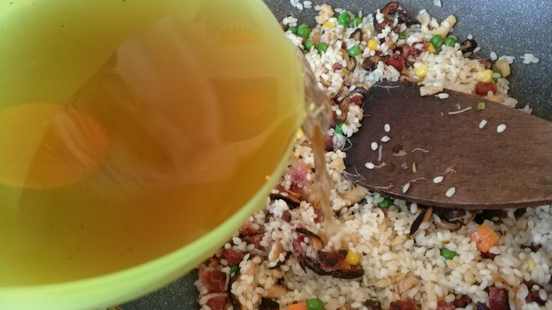 真正的生炒腊味糯米饭,加入一点泡香菇的水,不喜欢可以放清水,然后翻拌一下,盖锅盖焖一会