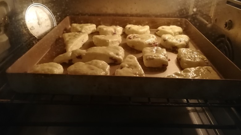 蔓越莓司康,烤箱180度预热5分钟,然后将做好的司康送入烤箱中层烘烤,上下火180度烘烤20分钟