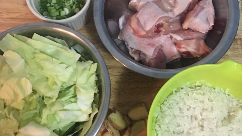 麻油鸡高丽菜饭,白米洗好后备用,棒棒腿洗净切小块,姜切片,高丽菜洗净沥干切块。