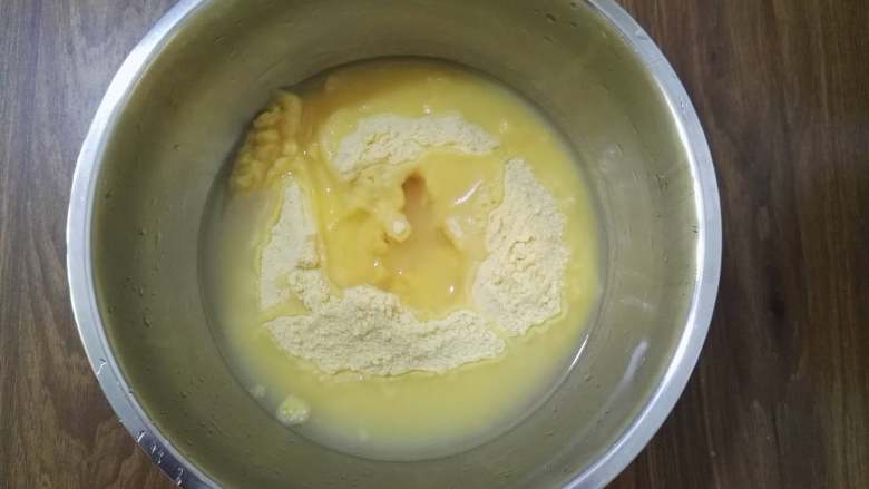 大枣花生玉米面发糕,将玉米面倒入盆中,加入开水用筷子搅拌均匀。