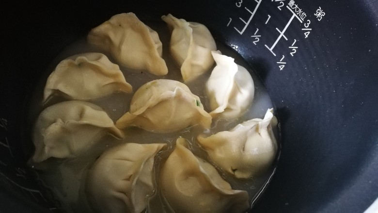 电饭煲+猪肉韭菜锅贴,倒入清水至饺子一半处 盖盖子 按下煮饭键