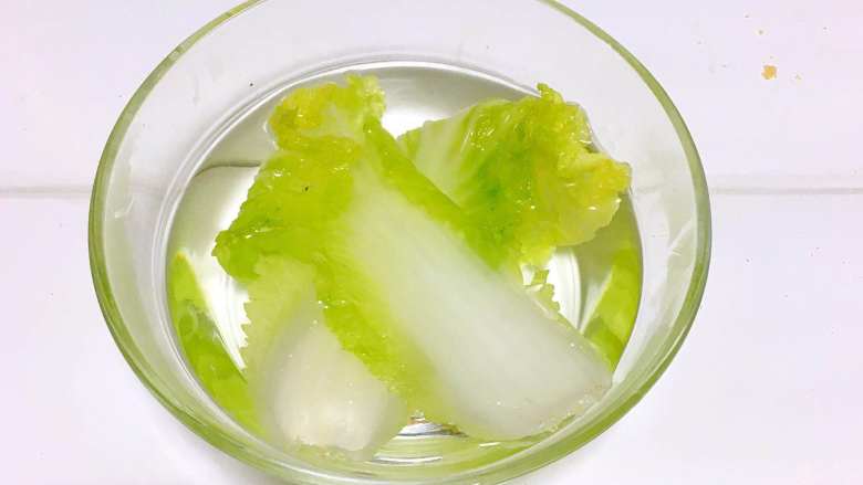 宝宝辅食之虾仁蔬菜厚蛋烧,2.焯好的娃娃菜捞出,放到冷水中冷却一下。
PS: 焯水后的蔬菜温度比较高,离水后与空气中的氧气接触容易产生热氧作用,营养素会流失。所以需要及时冷却降温,减少营养流失,还可以保持蔬菜翠绿的颜色。