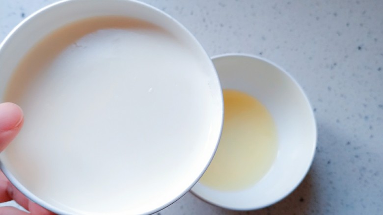 简易双皮奶,将结好奶皮的牛奶倒入蛋清里面,奶皮不要倒进去啊!一定要慢慢倒,角度要小,不然奶皮就进去了,切记要慢!不要倒完,留一点牛奶,让奶皮浮着,要是把牛奶全倒进去了,奶皮会直接沾到碗底。