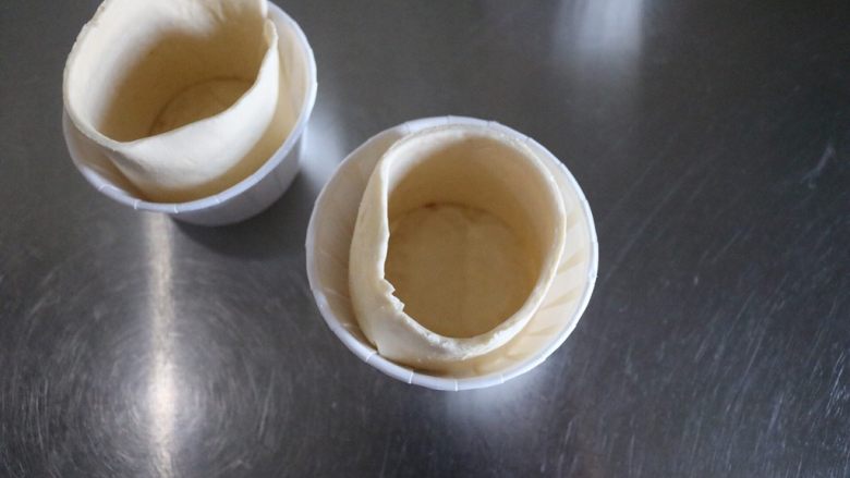 迷你培根鸡蛋酥饼,将长方形的酥皮放入蛋糕模具内，接头处捏紧