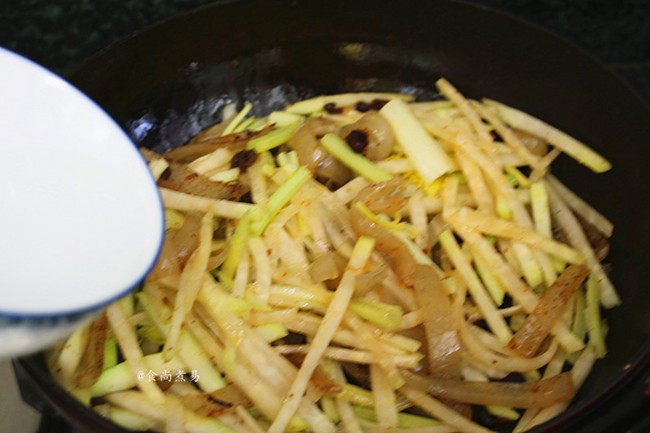 猪皮炒大头菜,撒点清水,拌匀、遮上锅盖焖煮片刻,让食材快速软化;
