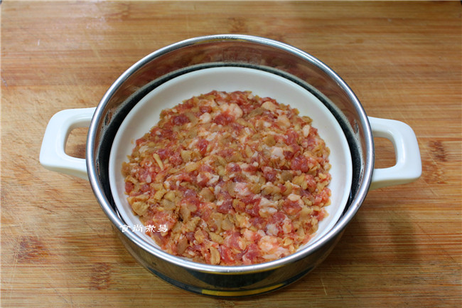 萝卜干肉饼饭,将拌好的肉饼盛入碟子中,稍稍压实表面,放在蒸笼里