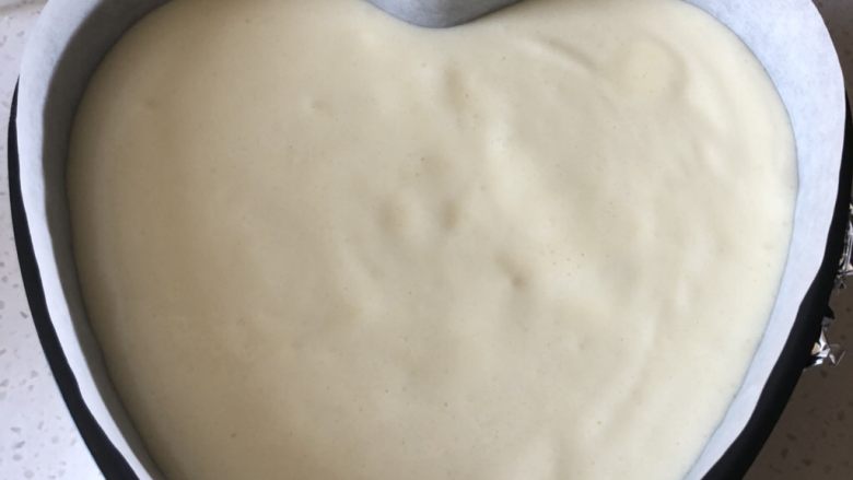 轻乳酪蛋糕cheese cake,把蛋糕糊从高处倒入倒入准备好的模具内,轻震模具,震出大气泡