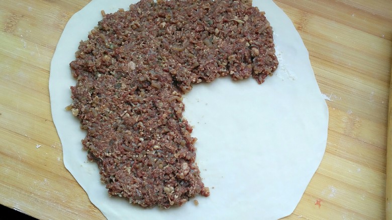 牛肉饼,看图,把肉馅铺上,留四分之一空下,另外肉馅也不要铺到太靠边,留两厘米。 肉馅铺多厚,看你有多少馅