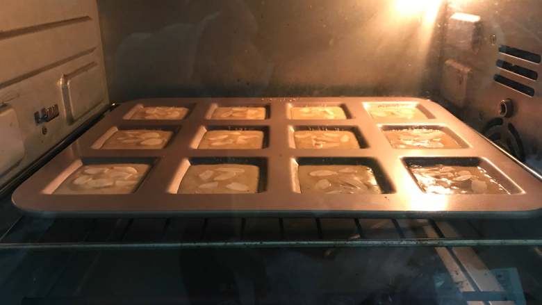 杏仁费南雪,入预热好的烤箱190度,中层,8分钟左右表面微泛金黄色即可。