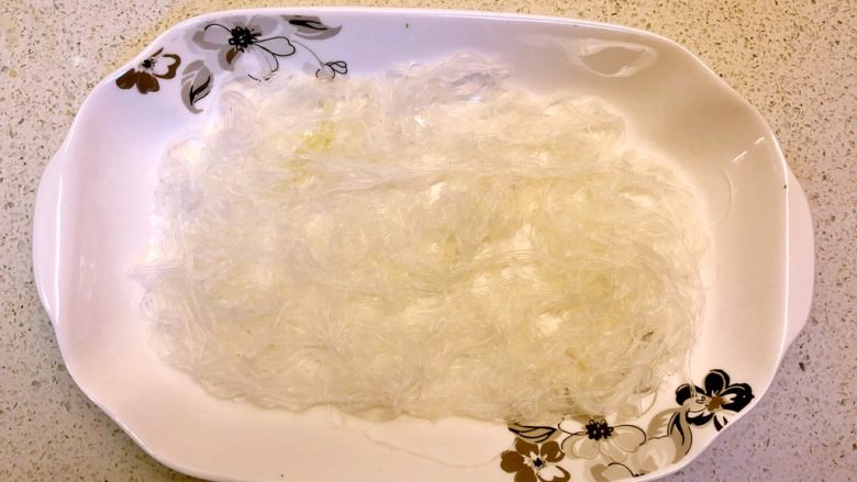 蒜蓉蒸生蚝,再来做另一份。
粉丝先泡软,铺在碟底,蒸熟。