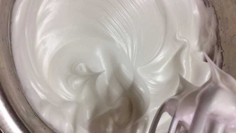 香橙杯子蛋糕,当提起打蛋器的时候,蛋白能拉出短小直立的尖角,表示已经达到了硬性发泡,已经完成了。把打发好的蛋白放进冰箱冷藏保存。