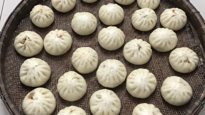 鲜肉包子,倒入圆形筛子里,分开晾凉。
