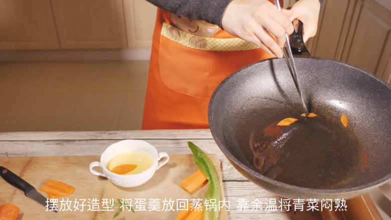 创意儿童餐 小鱼鸡蛋羹,胡萝卜和青菜叶都摆放好,再将蛋羹放入蒸锅,靠余温将菜叶闷熟。