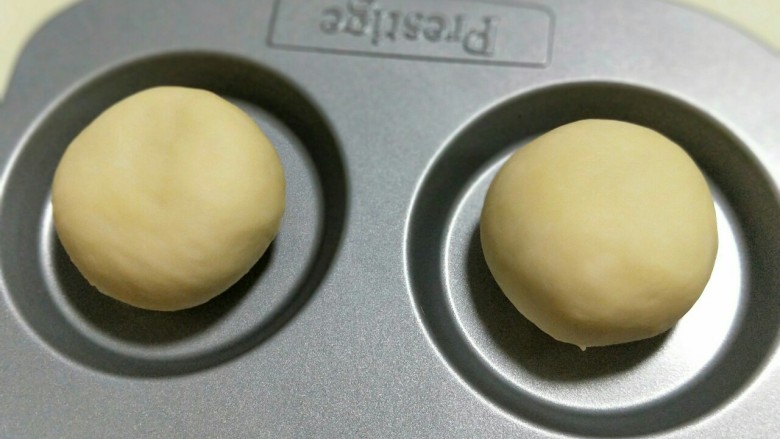 奶香小面包,揉圆放在模具中,依次做完,放入烤箱二次发酵。(天冷可以放一碗热水)