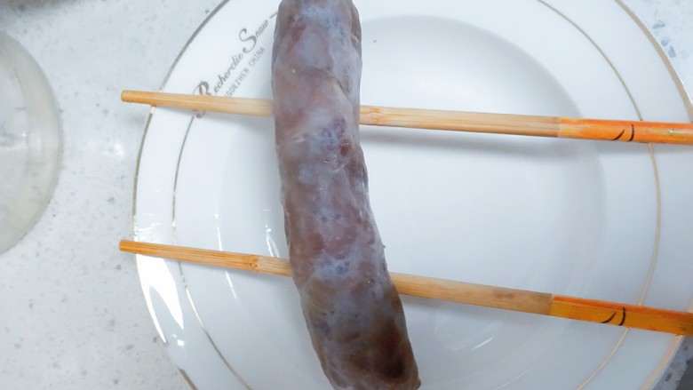 电饭煲+香菇腊香肠焖饭,用筷子夹住,在水龙头下面冲一下,然后放在盘子上面,借用筷子沥干水