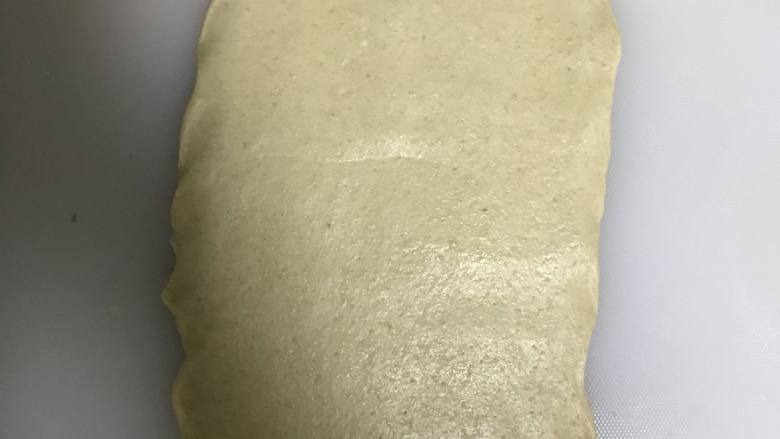全麦豆沙麻薯肉松软欧面包,取一个松弛好的面团擀开,最上面一端擀薄一点,一会收口用