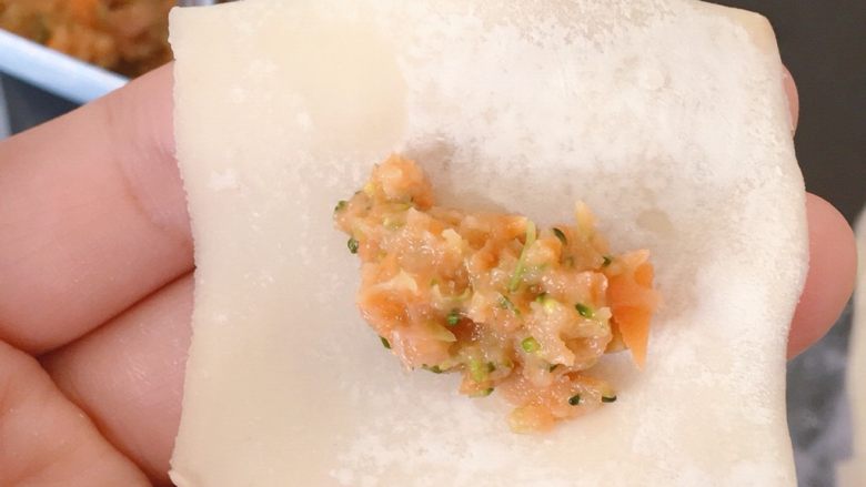 胡萝卜西兰花蛋黄猪肉小馄饨,第一种包法:取适量馅料放在饺子皮上(不要贪心,放多了会露馅😂)
