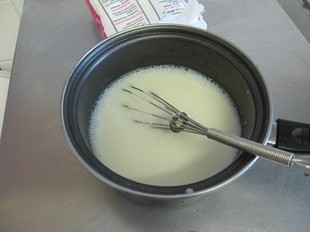 炸牛奶,将加热后的牛奶晾凉后,倒入放有保鲜膜的模具中,用手压实,放入冰箱冷冻