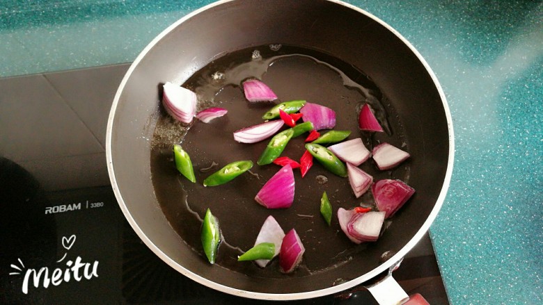 浓情芝士焗香辣鸡腿饭,炒锅加入橄榄油,放入洋葱和辣椒翻炒。