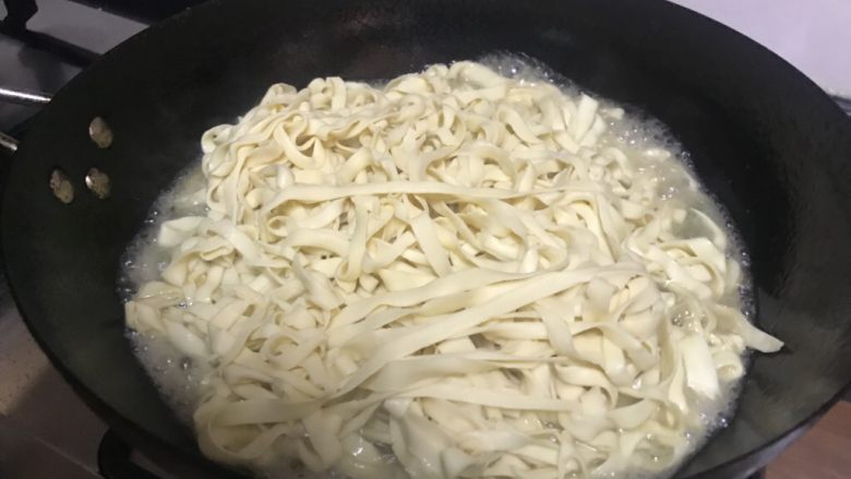 衩姐秘制豆角焖面,等锅里的水炖得只剩菜高度的1/4,土豆用筷子一戳已经能散开的时候,把香料包拿出(看吧,如果你不用茶包,此刻就要手工一粒一粒拣花椒),再把面条码在菜上。注意:千万别搅拌,就均匀地把面码开,把锅盖盖上,焖到锅里的汤快干。
然后打开锅盖,把炒得快熟的肉丝铺上,盖上盖子继续焖。